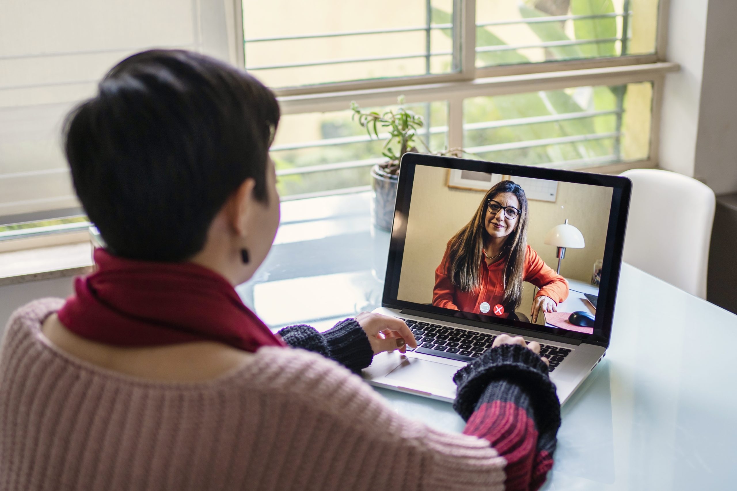 Japanese young woman talking to psychologist in video call